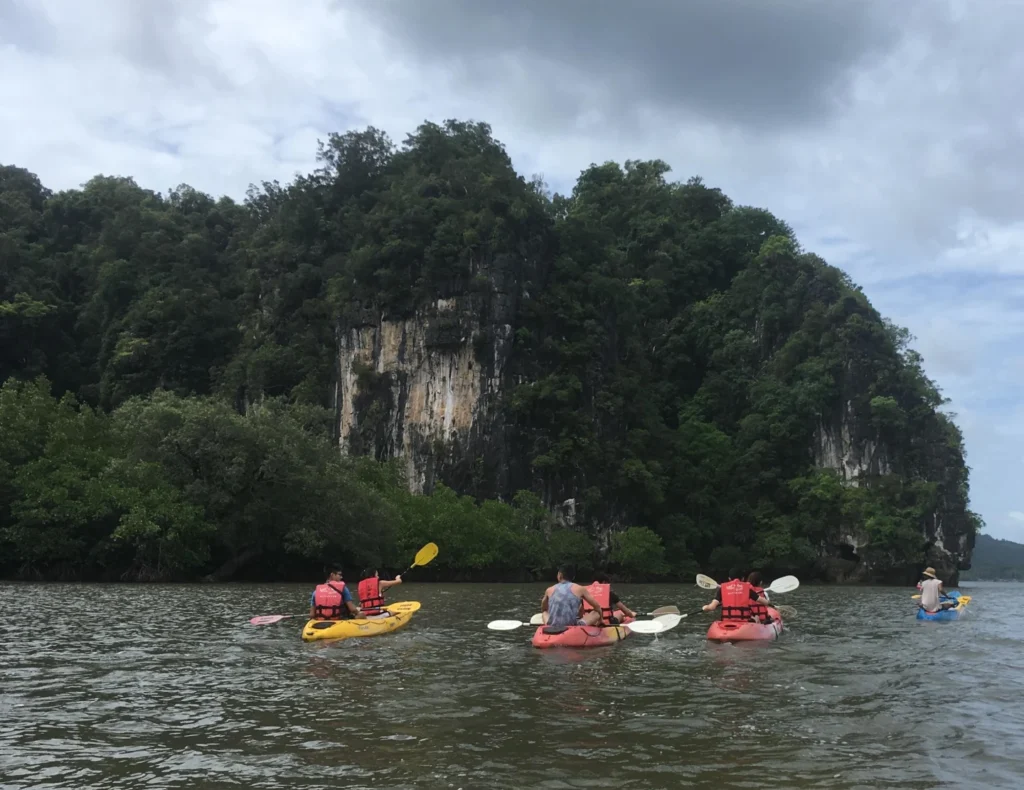 A kayak on calm water beside limestone cliffs and mangroves at Ao Thalane, Krabi