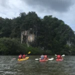 A kayak on calm water beside limestone cliffs and mangroves at Ao Thalane, Krabi